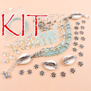 May include: A jewelry making kit with light blue glass beads, silver snowflake charms, and white seashells. The kit also includes a spool of clear thread and silver jump rings.