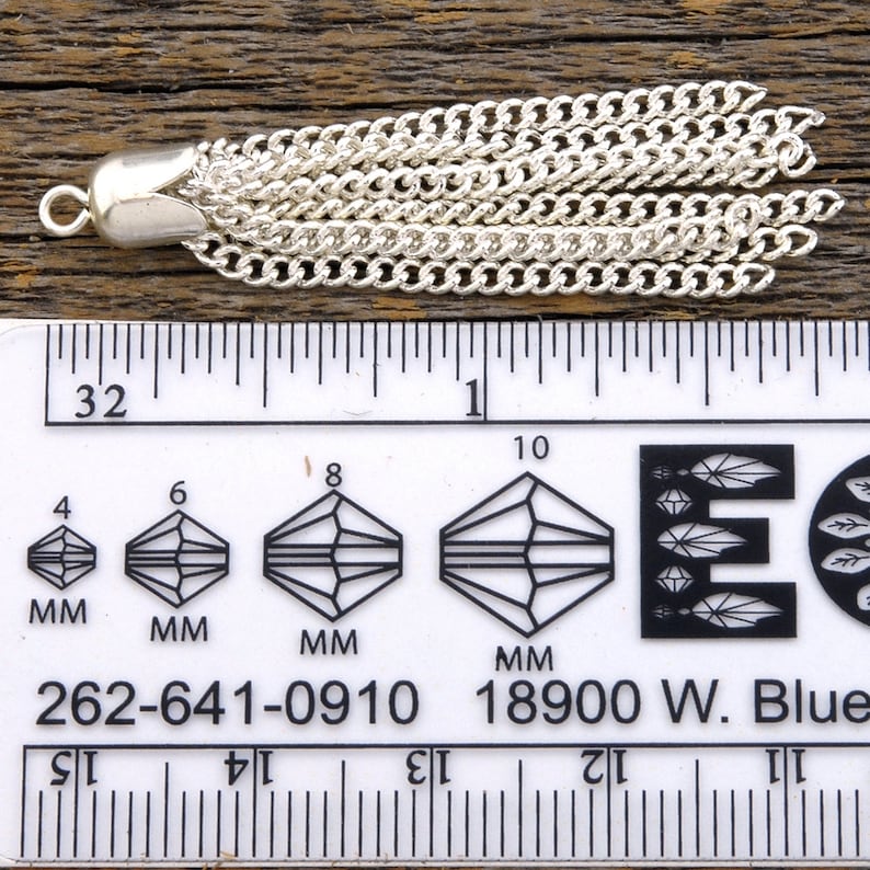 May include: A silver chain tassel with a loop at the top, measuring approximately 1 inch in length. The tassel is made of multiple strands of chain linked together.