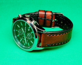 May include: A silver chronograph wristwatch with a green face and brown leather band. The watch has a date window and a second hand.