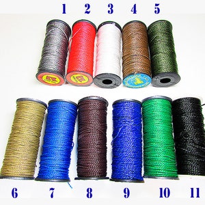 May include: Eleven spools of waxed thread in various colors, including gray, red, white, brown, green, gold, blue, dark brown, black, and dark green. The spools are numbered 1 through 11.