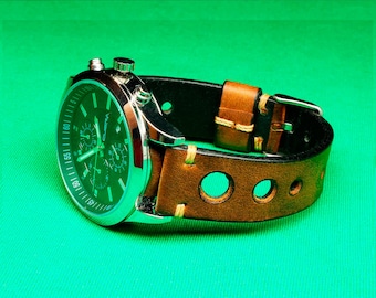 May include: A silver chronograph watch with a black face and a brown leather strap with holes. The strap has white stitching and a silver buckle.