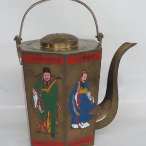 May include: A vintage brass teapot with a hexagonal body and a curved spout. The teapot features painted figures in green and blue robes, with red accents. It has a hinged lid and a handle.