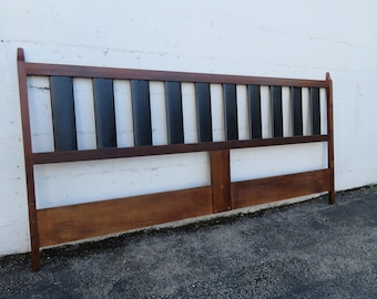 May include: A mid-century modern headboard with a dark brown frame and alternating black and light brown vertical slats. The headboard is made of wood and has a rectangular shape.