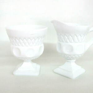 May include: A white milk glass creamer and sugar bowl set with a diamond pattern and raised dots. The set is in excellent condition.
