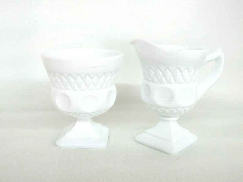 May include: A white milk glass creamer and sugar bowl set with a diamond pattern and raised dots. The set is in excellent condition.