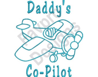 Könnte beinhalten: Eine blaue gestickte Darstellung eines kleinen Flugzeugs mit dem Text "Daddy's Co-Pilot" darunter.