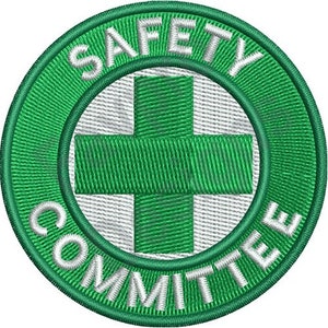 Op de afbeelding: Groen en wit geborduurd patch met de woorden "SAFETY COMMITTEE" in een cirkel rond een groen plusteken.