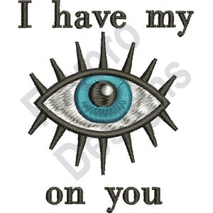 May include: A blue eye with black eyelashes and a white iris. The eye is surrounded by black rays. The text "I have my on you" is written below the eye.