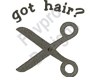 May include: Embroidered design featuring a pair of scissors in a textured gray color. The text "got hair?" is arched above the scissors in a matching gray color. The design is on a white background.