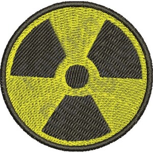 May include: Embroidered patch featuring the radiation symbol, a black trefoil within a yellow circle. The design is stitched with black and yellow thread, creating a textured appearance. The patch is circular and has a black border.