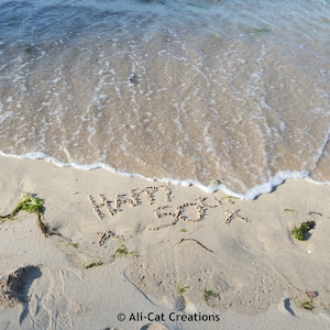 Happy 50e x: schrijven op zand op Carbis Bay Beach. Een individueel handgemaakte fotokaart gemaakt door Ali met een blanco binnenkant.