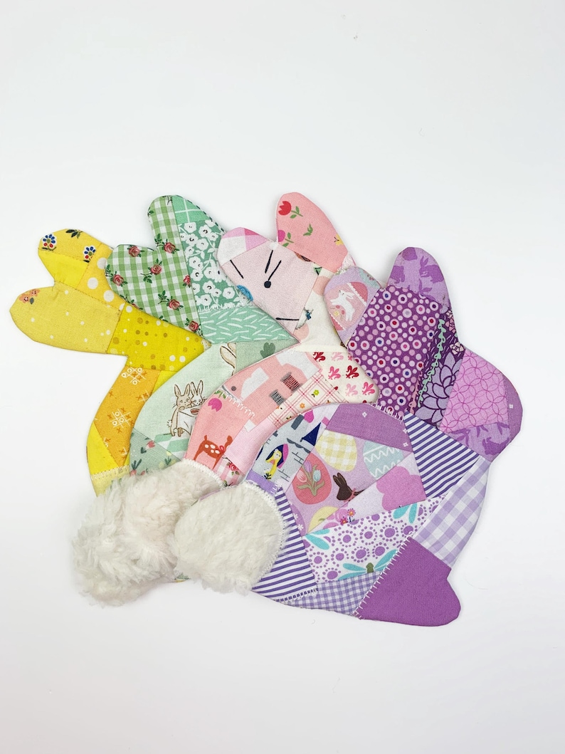 bunny shaped placemat and coaster sewing pattern, sewn with fabric scraps in pink , yellow, purple and green with a fake fur little tail.