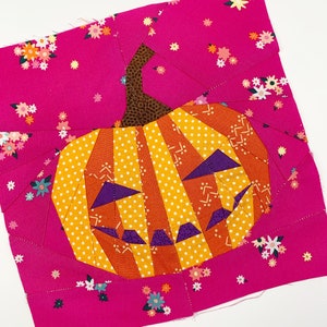 orange jack-o'-lantern quilt block on pink background fabric