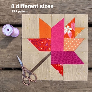 Könnte beinhalten: Ein quadratischer Quiltblock mit einem Ahornblatt-Motiv in leuchtendem Orange, Pink und floralen Mustern auf beigem Hintergrund. Der Text 8 different sizes FPP pattern ist sichtbar. Eine Garnrolle und verzierte Metallschere liegen daneben.