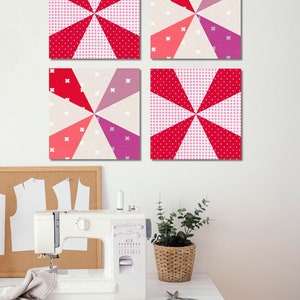4 Kaleidoscope quilt blocks hanging on the wall on top of a sewing machine