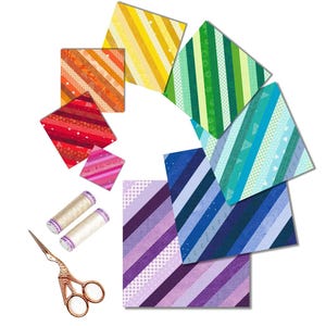 Puede incluir: Un surtido de cuadrados de tela arcoíris con rayas diagonales, dispuestos en un semicírculo. Se incluyen dos carretes de hilo blanco y un par de tijeras doradas.