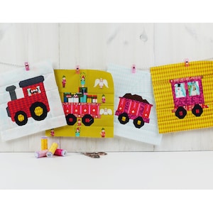 May include: Four colorful fabric squares with a Christmas train theme. Each square features a different train car with a unique design. The train cars are red, pink, and brown with yellow wheels. The squares are hanging on a white string with pink clothespins.