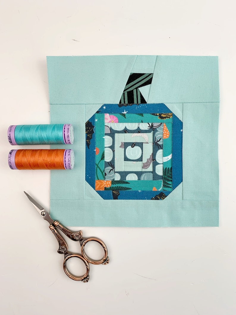 log cabin pumpkin quilt blocks in teal colors on mint background.log cabin pumpkin quilt block pattern in 5 different sizes, from 4x4 inch for ornaments to 6x6, 8x8, 10x10 and 12x12 inches for all sorts of amazing Halloween sewing projects. Use your favorite fabrics to fussy cut the center and turn these amazing beauties into your own pumpkin patch.