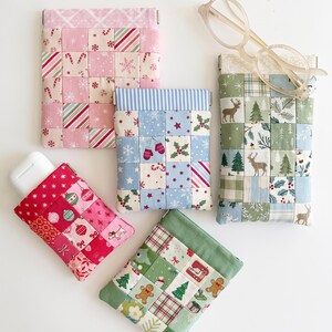 May include: Four rectangular fabric pouches with metal squeeze frames, featuring patchwork designs of holiday motifs including gingerbread men, reindeer, candy canes, and ornaments in pink, blue, green, and red color palettes.