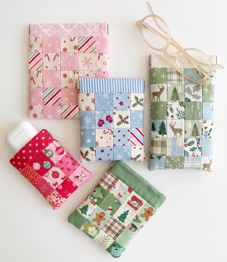 May include: Four rectangular fabric pouches with metal squeeze frames, featuring patchwork designs of holiday motifs including gingerbread men, reindeer, candy canes, and ornaments in pink, blue, green, and red color palettes.