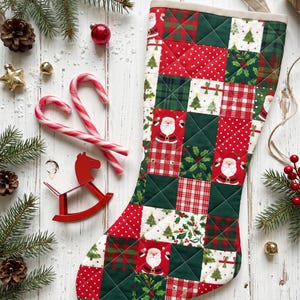 May include: A quilted Christmas stocking featuring a patchwork design of red, green, and white squares. The fabric patterns include illustrations of Santa Claus, Christmas trees, holly leaves, red and white polka dots, and plaid.