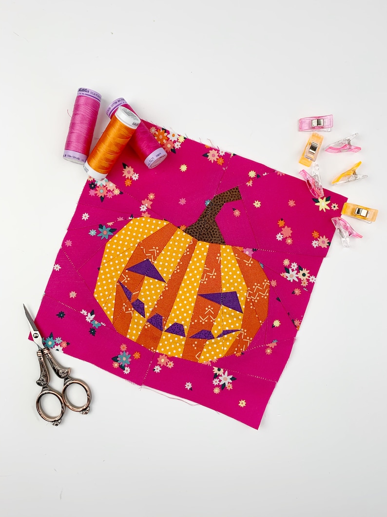 orange jack-o'-lantern quilt block on pink background fabric