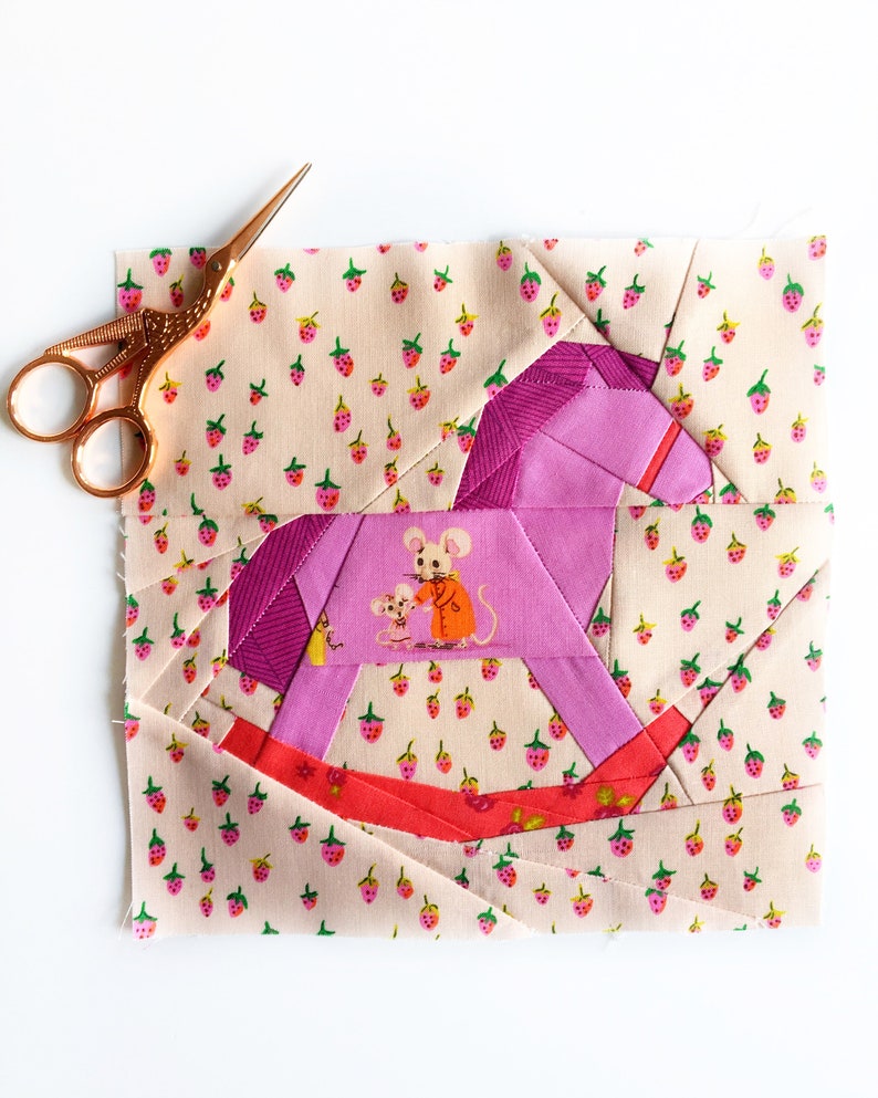 Rocking horse quilt block pattern, pink and red rocking horse on multicolored background