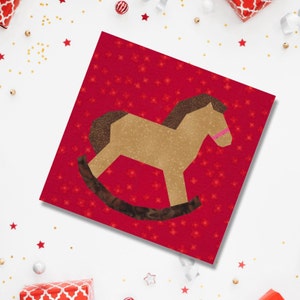 Rocking horse quilt block pattern, brown and pink rocking horse on red background
