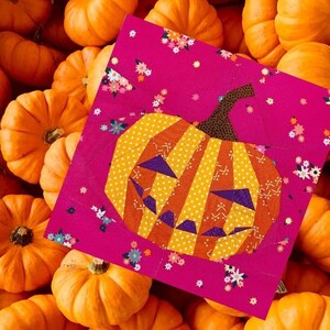 orange jack-o'-lantern quilt block on pink background fabric