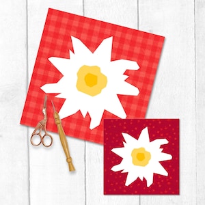 Puede incluir: Dos cuadrados rojos con diseños de flores blancas, uno con un patrón de cuadros y el otro con un patrón de estrellas. Un par de tijeras doradas y una herramienta de madera están al lado del cuadrado más grande. El fondo es blanco.