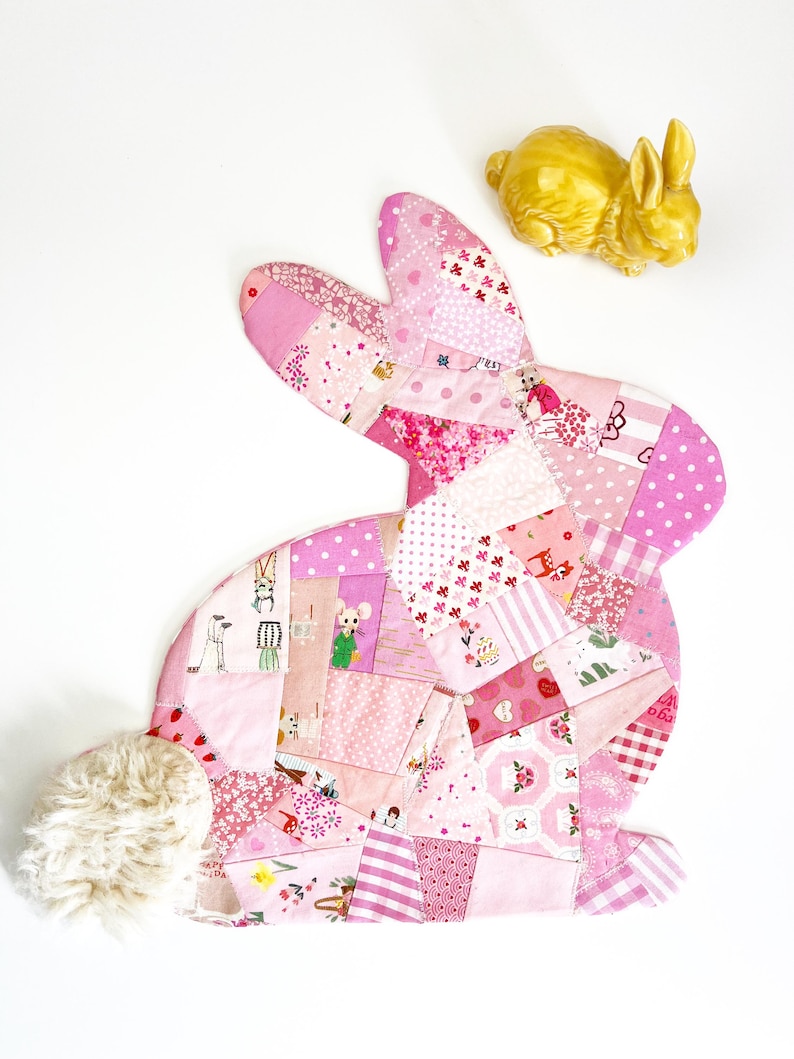 bunny shaped placemat and coaster sewing pattern, sewn with fabric scraps in pink with a fake fur little tail.
