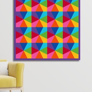 Kaleidoscope quilt pattern in rainbow colors hanging on the wall in front of a yellow velvet chair