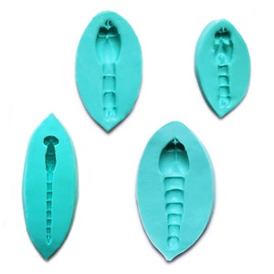May include: Four teal blue silicone moulds shaped like leaves, each with a detailed impression of a shrimp inside.