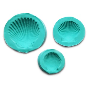 May include: Three teal blue silicone molds shaped like seashells. The molds are different sizes, with the largest mold in the center of the image.