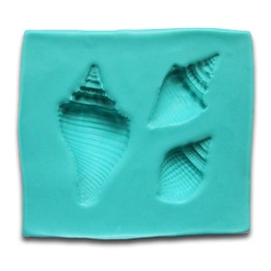 May include: A turquoise silicone mold with three different seashell shapes. The mold is designed for making edible decorations.