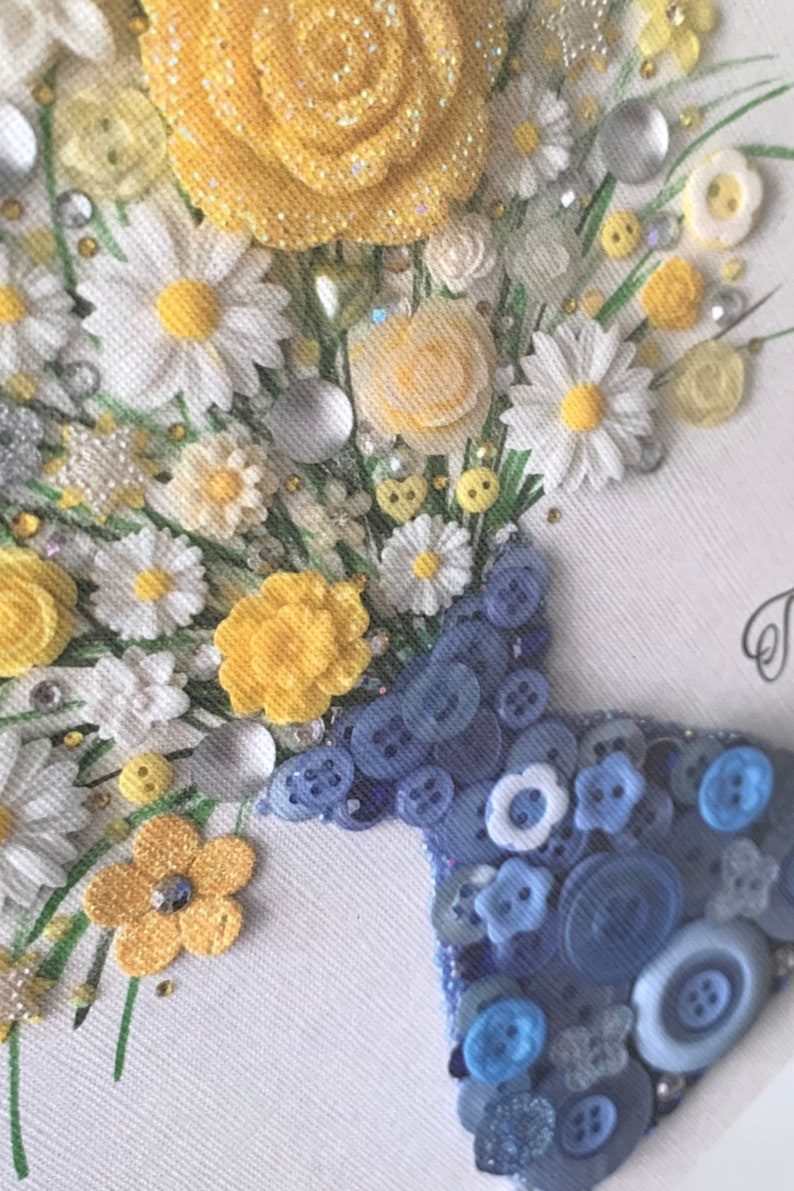 May include: A white canvas with a bouquet of yellow and white flowers made from buttons and other embellishments. The flowers are arranged in a blue button vase.