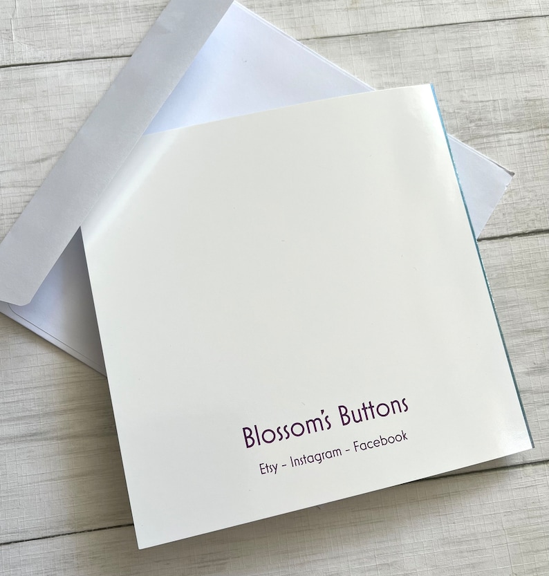May include: A white card with a purple text that reads "Blossom's Buttons" and "Etsy - Instagram - Facebook".