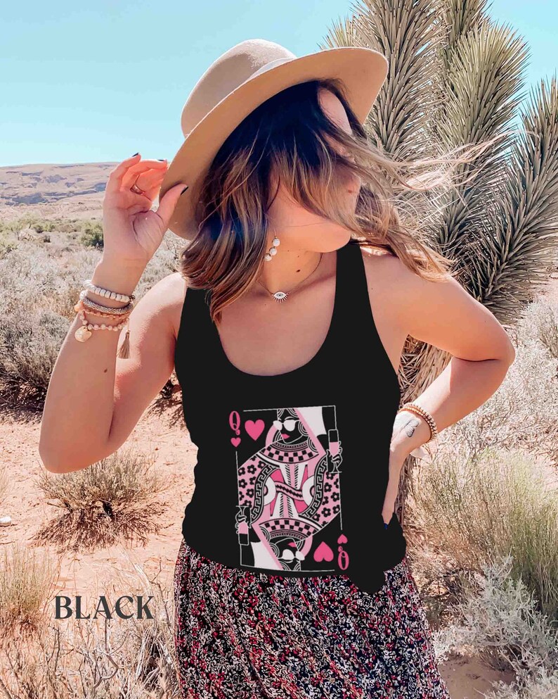 K&ouml;nnte beinhalten: Schwarzes Tanktop mit einem Grafikdruck der Spielkarte der Herzdame. Die Dame tr&auml;gt eine Sonnenbrille und ein rosa Kleid mit einem schwarz-wei&szlig;en Muster. Die Karte ist von rosa Herzen umgeben.