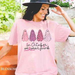 May include: Pink t-shirt with four ghosts wearing different pink patterns. The text "in October we wear pink" is below the ghosts with a pink ribbon.