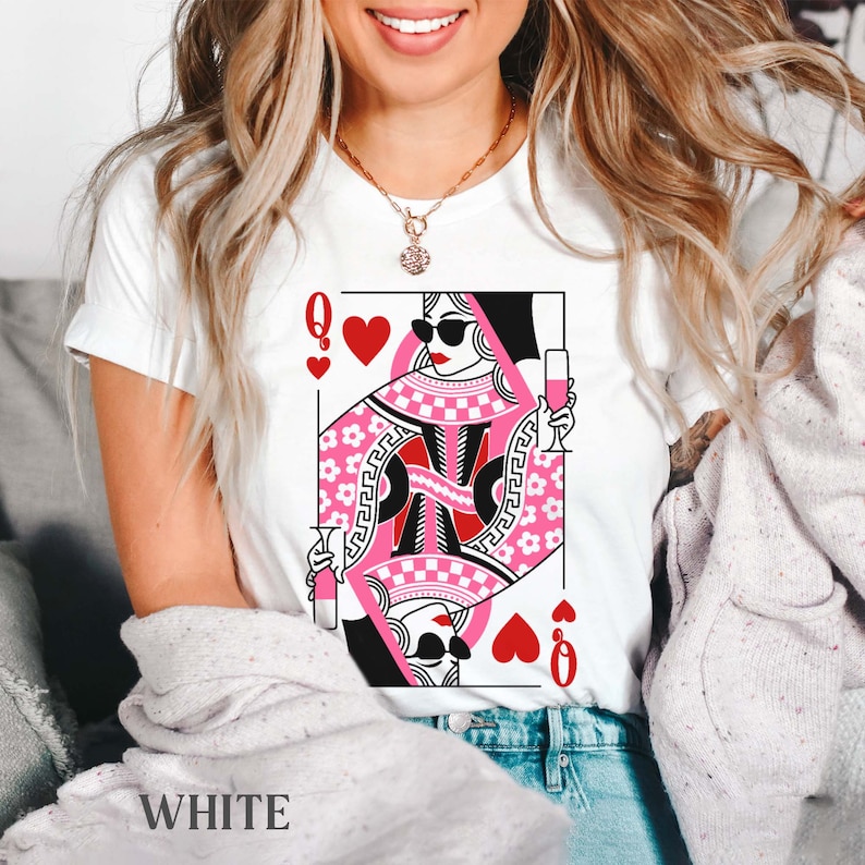 K&ouml;nnte beinhalten: Wei&szlig;es T-Shirt mit einem Grafikdruck der Herzdame aus einem Kartenspiel. Die Dame tr&auml;gt eine Sonnenbrille und h&auml;lt ein Glas Wein in der Hand. Die Karte ist rosa und rot mit einem wei&szlig;en Karomuster.