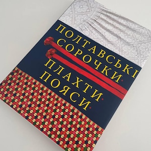 May include: A book cover with a blue background and yellow text that reads "Poltavsky Sorochky. Plakhti. Poyasi." The cover features a white lace fabric and red and white embroidery.