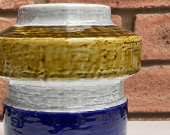May include: A ceramic vase with a blue, white and brown glaze. The vase has a wide mouth and a narrow base.