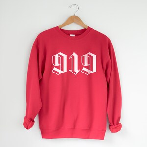 May include: Red sweatshirt with white '919' printed in a gothic font.