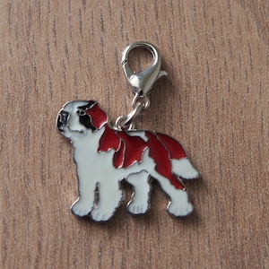 May include: A silver charm featuring a white and red dog with black markings. The charm has a silver loop for attaching to a bracelet or necklace.
