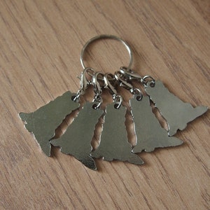 May include: A silver key chain with six silver charms shaped like dogs. The charms are attached to a silver ring.