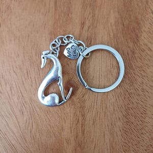 Può includere: Portachiavi d'argento con un ciondolo a forma di levriero e un ciondolo a forma di cuore con la scritta "Amo il mio cane".
