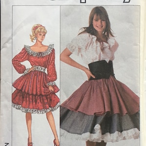 May include: Simplicity sewing pattern number 8447 for a skirt and blouse. The pattern includes two different styles of skirts, one with a tiered ruffle and the other with a gingham print. The blouse has a ruffled neckline and short sleeves.