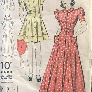 May include: Vintage Du Barry sewing pattern featuring illustrations of two dresses. One is a yellow dress with red trim and buttons, the other is a red dress with white heart patterns. The pattern is size 14 and includes the text "Easily-Made".