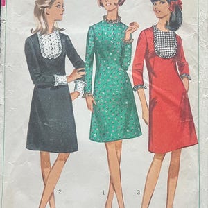 May include: Vintage Simplicity sewing pattern featuring three dresses. The dresses are in black, green floral, and red. The pattern includes the text "6731 Simplicity", "Miss Size 14 Bust 34", and the price.