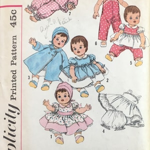 May include: A vintage sewing pattern for making doll clothes. The pattern includes seven different outfits for a 20-inch doll, including a dress, a coat, a pair of overalls, and a pair of pajamas. The pattern is printed on a white background with black and red text. The pattern number is 3669.